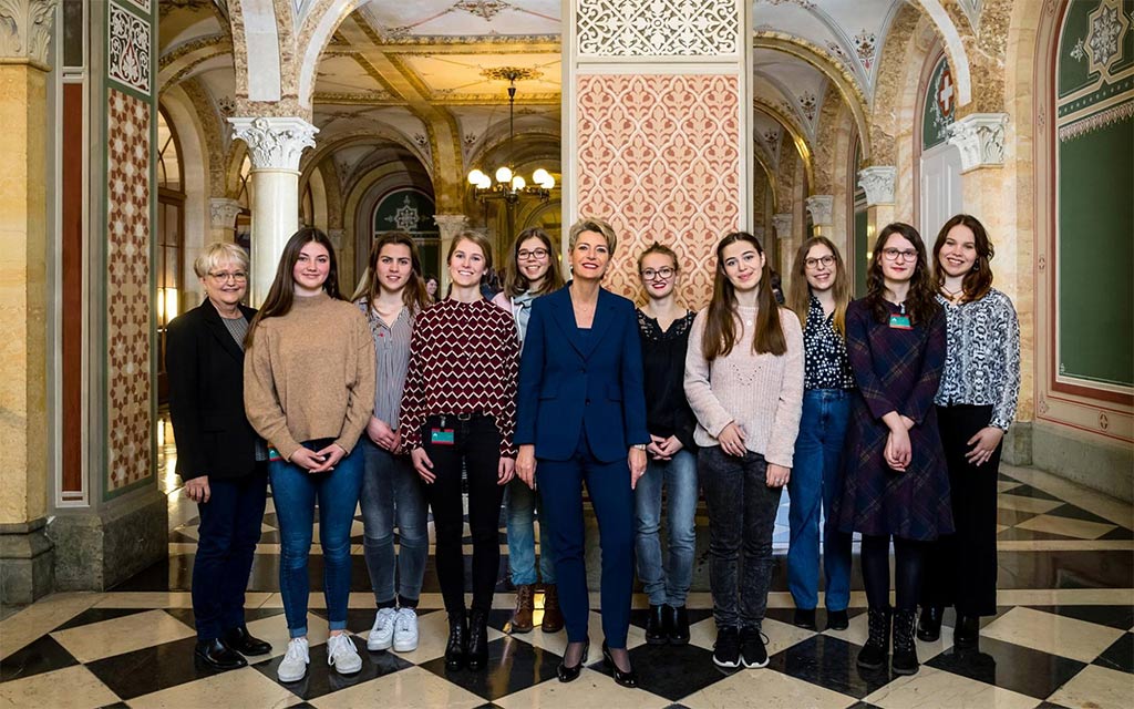 Photo de groupe au Palais fédéral ouest: la conseillère fédérale Karin Keller-Sutter, entourée des jeunes femmes lucernoises invitées à Berne à l’occasion de la journée internationale des femmes
