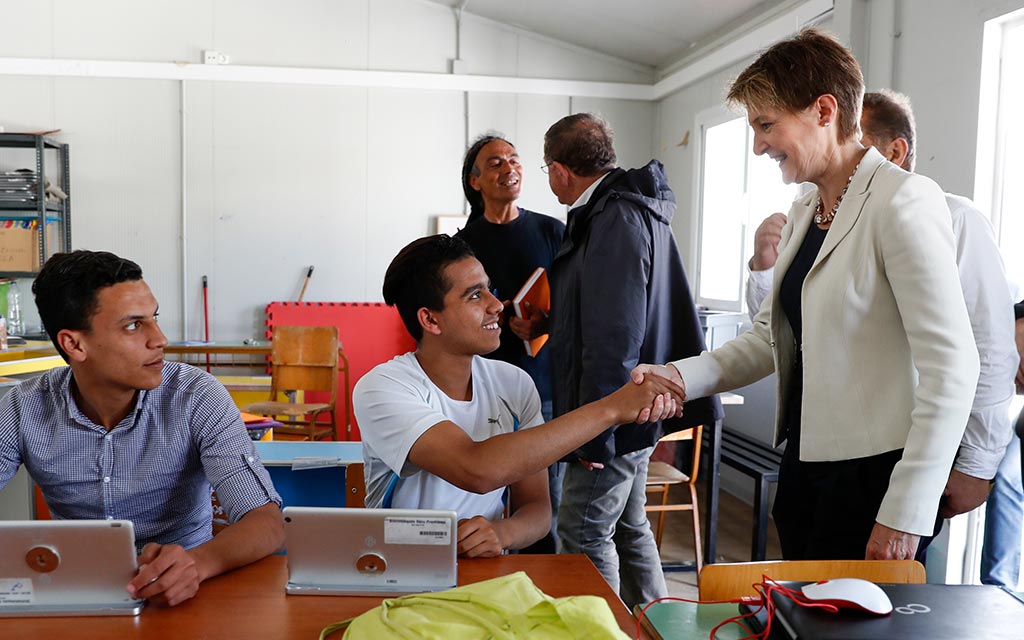 Durante la visita al centro di accoglienza di Moria, la consigliera federale Simonetta Sommaruga saluta dei rifugiati in un’aula scolastica
