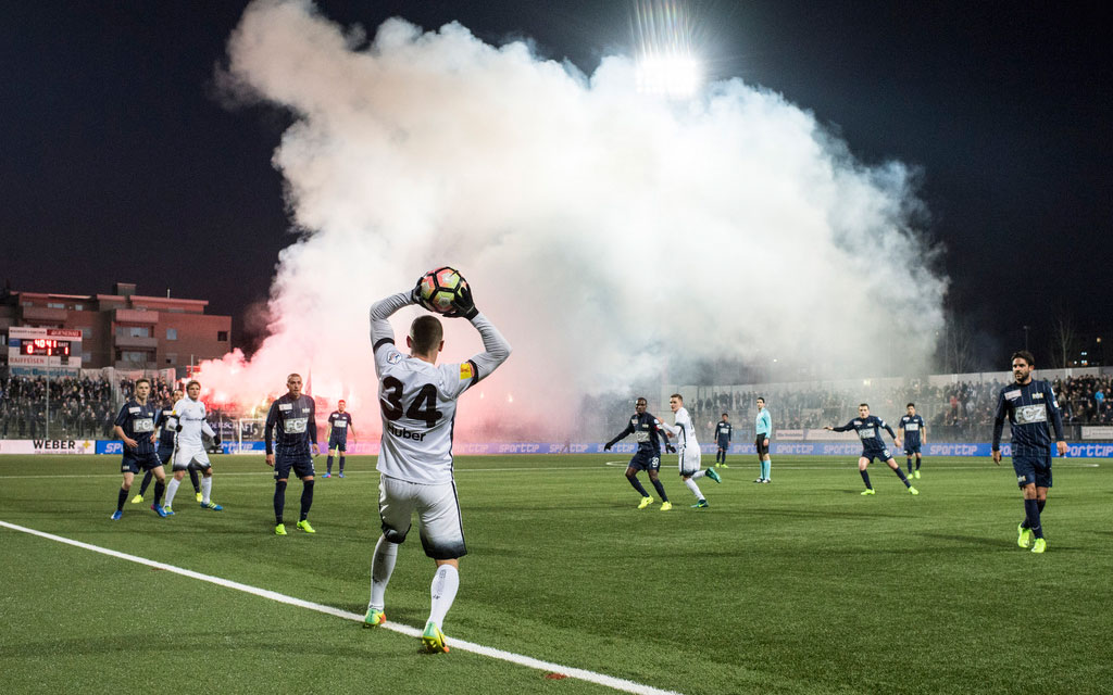 Tifosi accendono pezzi pirotecnici durante una partita di calcio