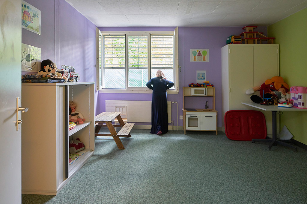 Au centre fédéral pour requérants d’asile d’Embrach, une femme portant le voile regarde par la fenêtre.